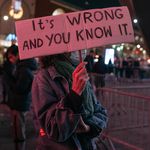 A protester holds up a sign reading "It's Wrong And You Know It" at a demonstration in Brooklyn inspired by the Kyle Rittenhouse verdict.
